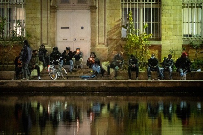 Des fumeurs de crack allument leurs pipes à crack sur les quais de la place Stalingrad à Paris.