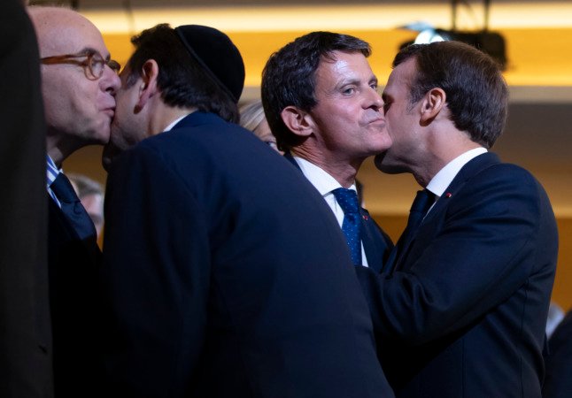 Le président Macron embrasse l'ancien Premier ministre Manuel Valls, tandis que le président du Consistoire central israélite de Paris Joël Mergui embrasse l'ancien ministre français de l'Intérieur Bernard Cazeneuve lors de l'inauguration du Centre européen du judaïsme. 