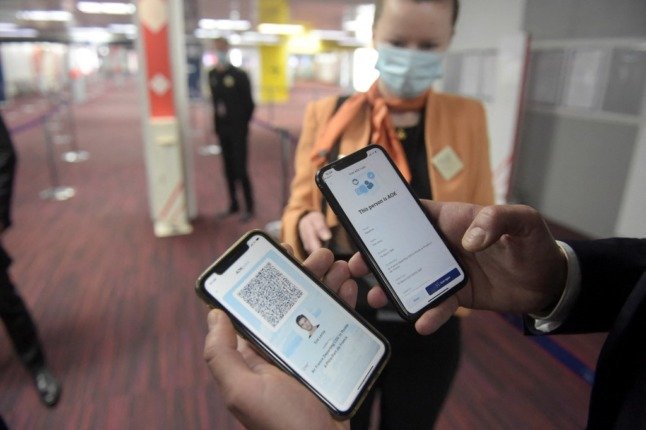 Un homme présente des smartphones avec l'application AOK pass dans la zone des arrivées de l'aéroport Roissy-Charles de Gaulle. 