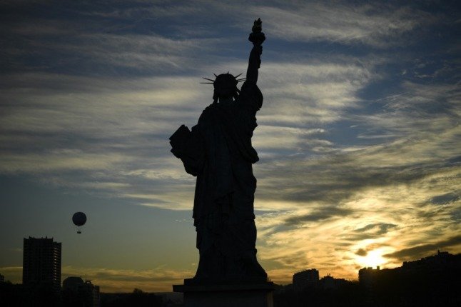 Une réplique de la Statue de la Liberté se dresse sur l'Ile de Cygnes à Paris au coucher du soleil 