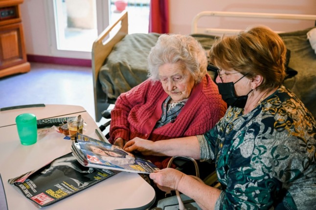 Aline Blain, 110 ans, lit un magazine avec sa fille Monique, dans le sud de la France.