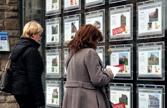 Des acheteurs potentiels regardent dans une agence immobilière en France.