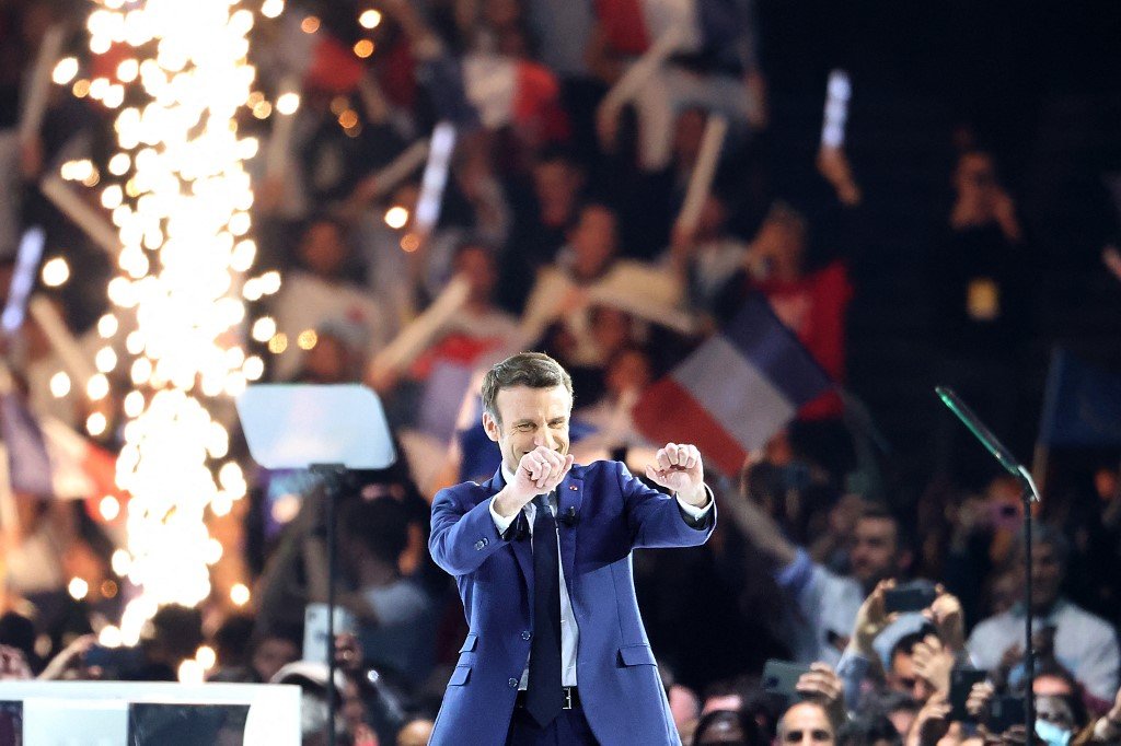Emmanuel Macron salue ses partisans au milieu des feux d'artifice lors de son premier meeting de campagne.