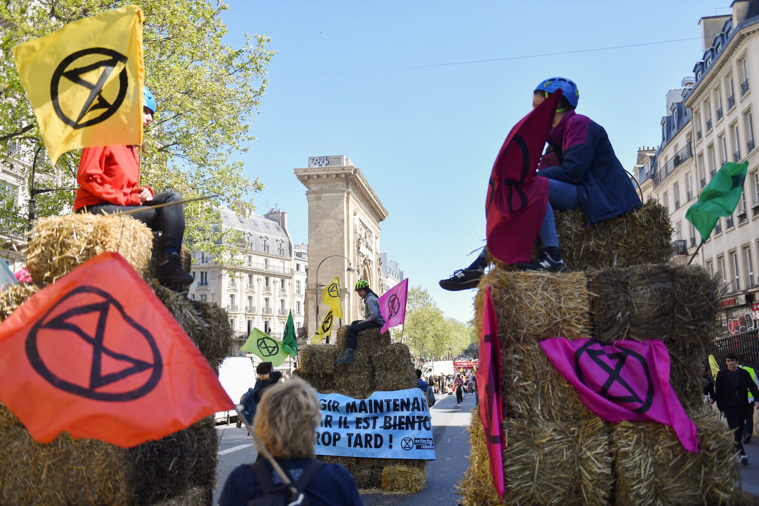 Des militants de la Rébellion pour l'extinction tiennent des pancartes avec le logo lors d'une manifestation à Paris.