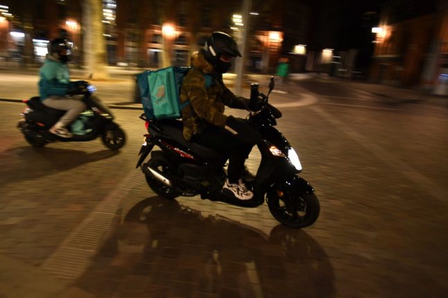 Un livreur de nourriture Deliveroo sur un scooter