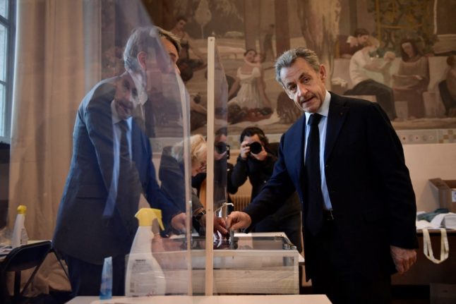 L'ancien président français Nicolas Sarkozy dépose son bulletin de vote pour le premier tour de l'élection présidentielle française dans un bureau de vote à Paris