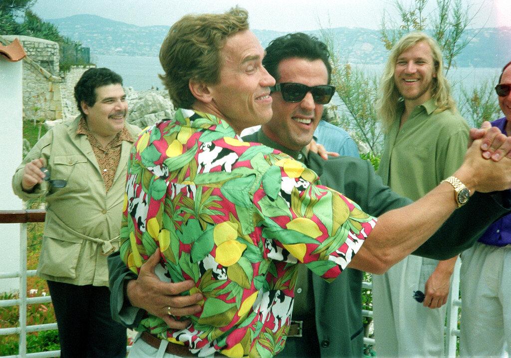 Les stars américaines de l'action Sylvester Stallone et Arnold Schwarzenegger organisent en plaisantant une danse le 13 mai 1990, alors qu'ils assistent à Cannes.