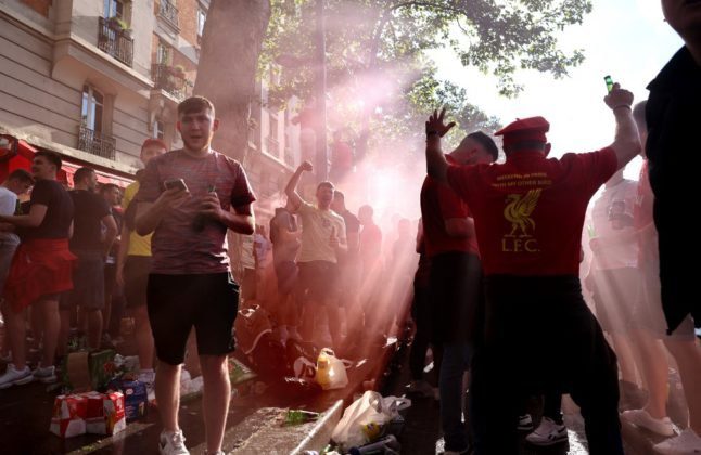 Des supporters du Liverpool FC dansent et boivent près d'un bar à Paris, le 27 mai 2022, à la veille de la finale de la Ligue des champions de football entre Liverpool et le Real Madrid.