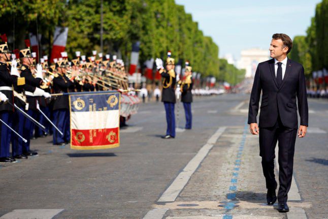 Le président français Emmanuel Macron passe en revue les troupes lors du défilé militaire du jour de la Bastille sur l'avenue des Champs-Élysées à Paris, le 14 juillet 2022.