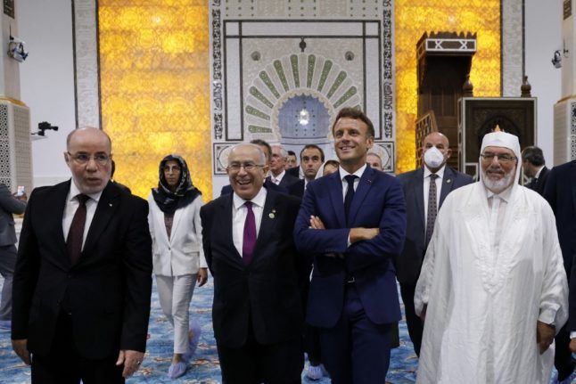Le président français Emmanuel Macron (3e R), le ministre algérien des Affaires étrangères Ramtane Lamamra (2e L) et l'imam de la Grande Mosquée d'Alger Mohamed Mamoun El-Kacimi El-Hassani (R) visitent la Grande Mosquée d'Alger