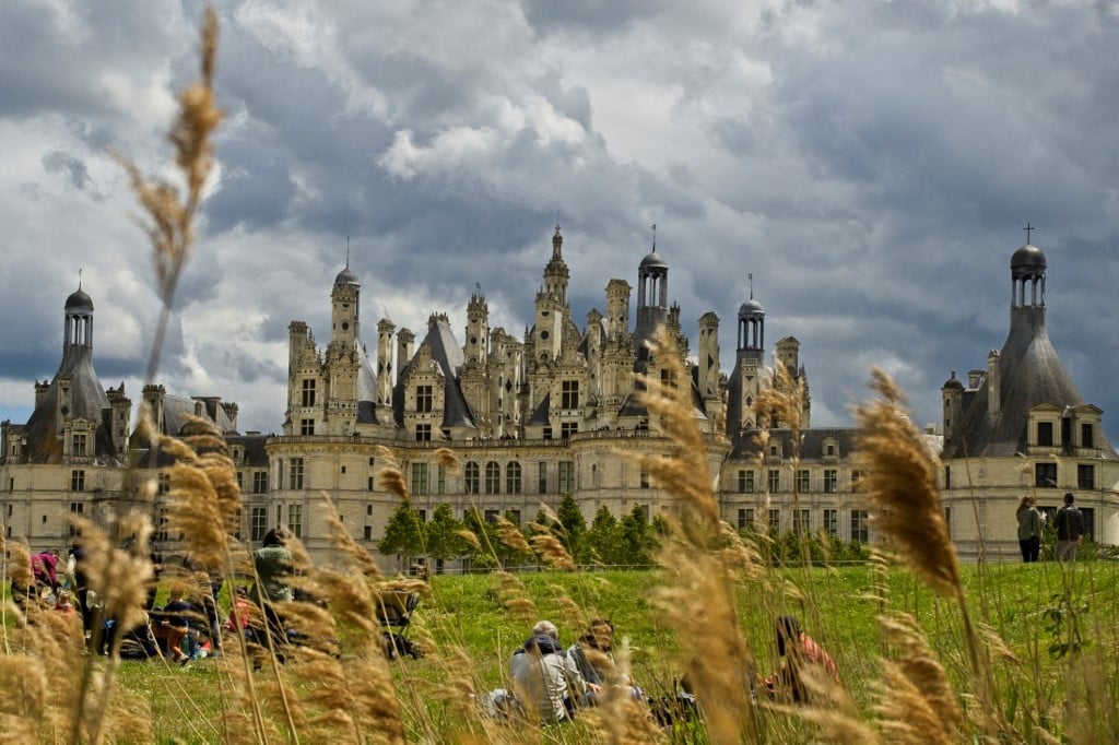 Les gens s'assoient sur l'herbe devant le château de Chambord